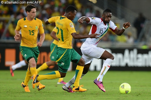 Le drapeau du Mali et le drapeau de l'Afrique du Sud se croisant sur un terrain de football